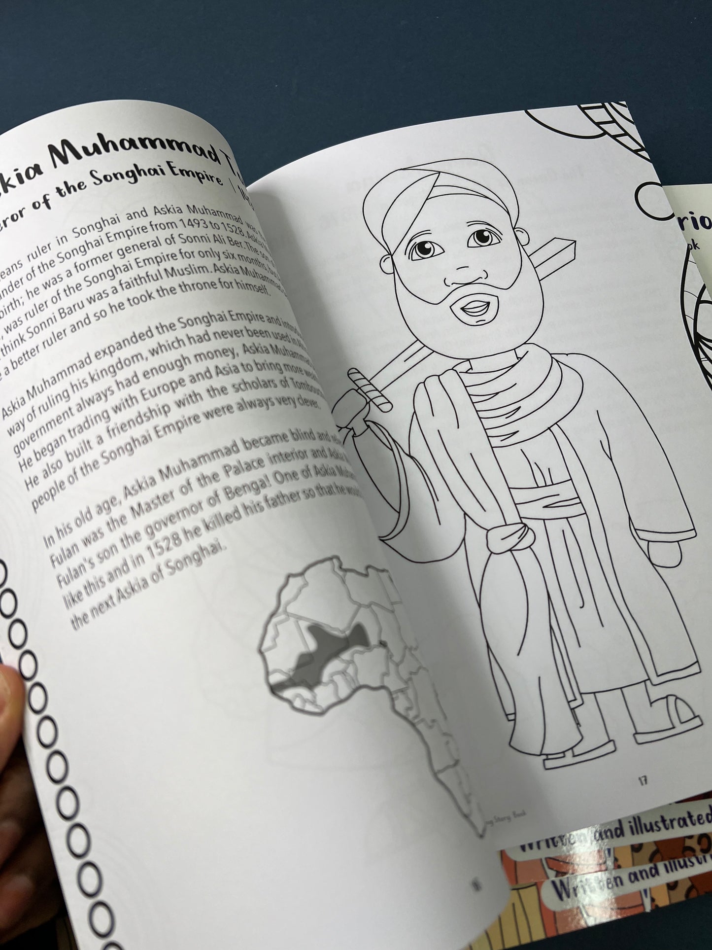 Open book with a coloring page of a character and text on a dark background